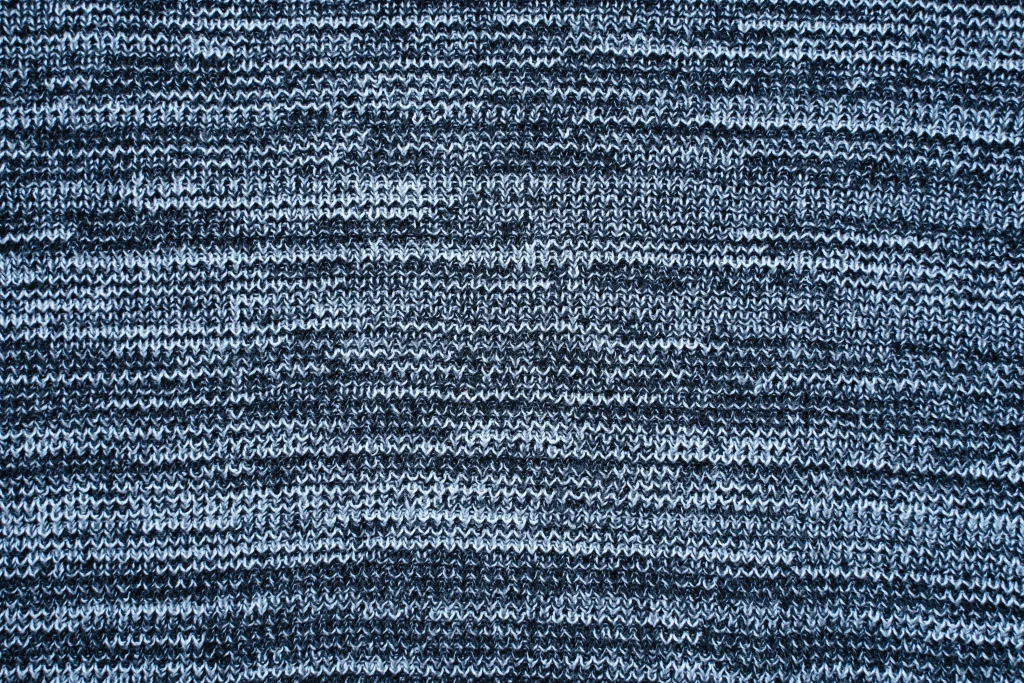 Close-up shot of high-quality knit fabric texture, emphasizing material excellence in apparel production.